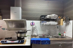 A kitchen with a stove, a water dispenser, and a sink. - Nha Cua Bot – 5BR 4BA in DaLat (Dalat)