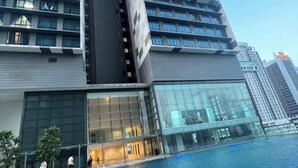 A modern hotel with a large glass facade, a swimming pool, and a multi-story structure. - Setia sky 88 Foo homestay (Johor Bahru)