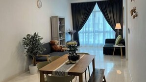 A modern living room with a dining area, a large window with curtains, a ceiling fan, and a potted plant. - Setia sky 88 Foo homestay (Johor Bahru)
