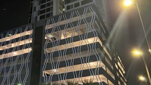 A modern building with a unique wavy facade design and multiple illuminated windows at night. - Setia sky 88 Foo homestay (Johor Bahru)