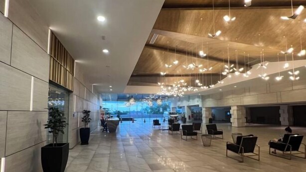 A spacious lobby with a high ceiling, modern lighting fixtures, and a seating area with chairs. - Setia sky 88 Foo homestay (Johor Bahru)