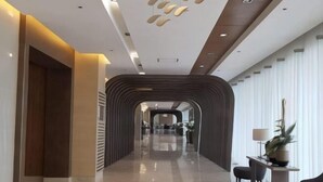 A modern hotel lobby with a sleek, curved ceiling design and a polished floor. - Shore 3 Residences Tower 2, Lap Pool and Amenities (Pasay)