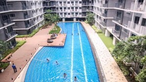 A swimming pool surrounded by multi-story residential buildings with balconies. - Shore 3 Residences Tower 2, Lap Pool and Amenities (Pasay)