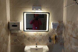 A bathroom with a mirror, sink, hand dryer, and soap dispenser. - Golden Punjabi House (Zirakpur)