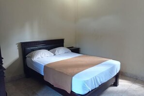 A single bed with a wooden headboard, white bedding, and a brown throw blanket. - Hotel Mawar Sari Mitra RedDoorz (Bali)