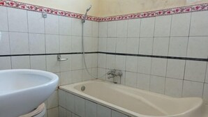 A bathroom with a toilet, a sink, and a bathtub. - Hotel Mawar Sari Mitra RedDoorz (Bali)