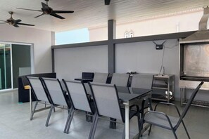 A conference room with a long table, chairs, ceiling fans, and a projector screen.