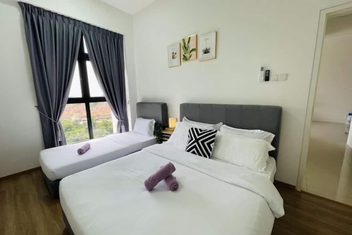 Een hotelkamer met twee bedden, een groot raam met gordijnen, een nachtkastje met een lamp en een kunstwerk aan de muur.