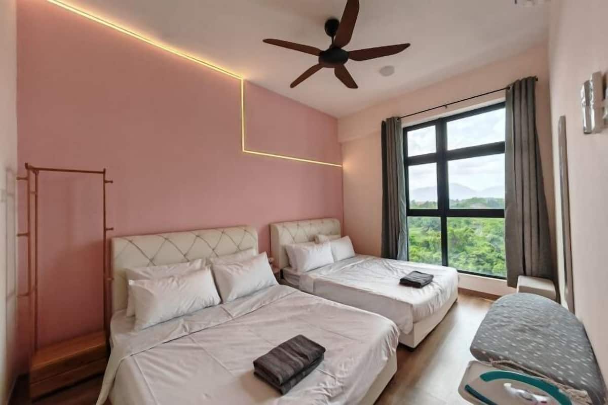 Een hotelkamer met twee bedden, een plafondventilator, een groot raam met uitzicht en een nachtkastje.