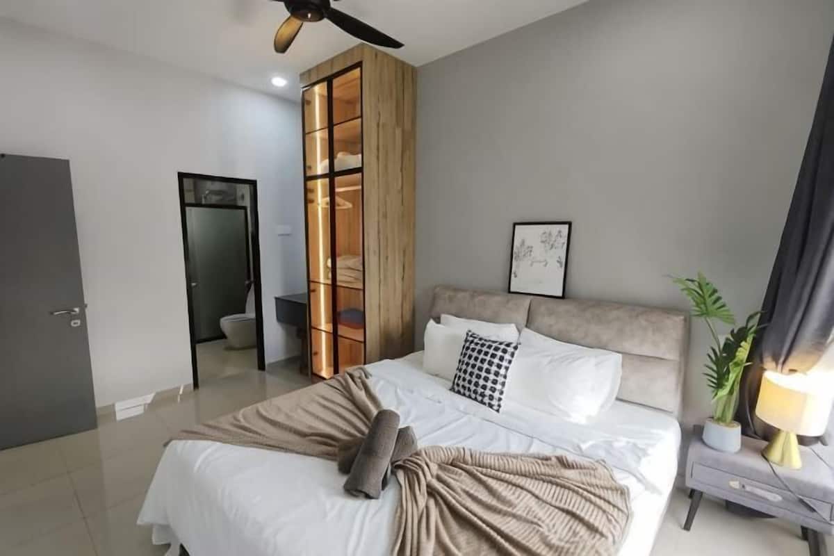 Een slaapkamer met een bed, nachtkastje en een kledingkast.