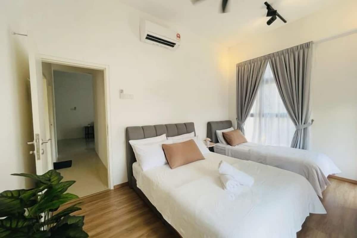 Een hotelkamer met twee bedden, een airconditioning, een plafondventilator en uitzicht door het raam.