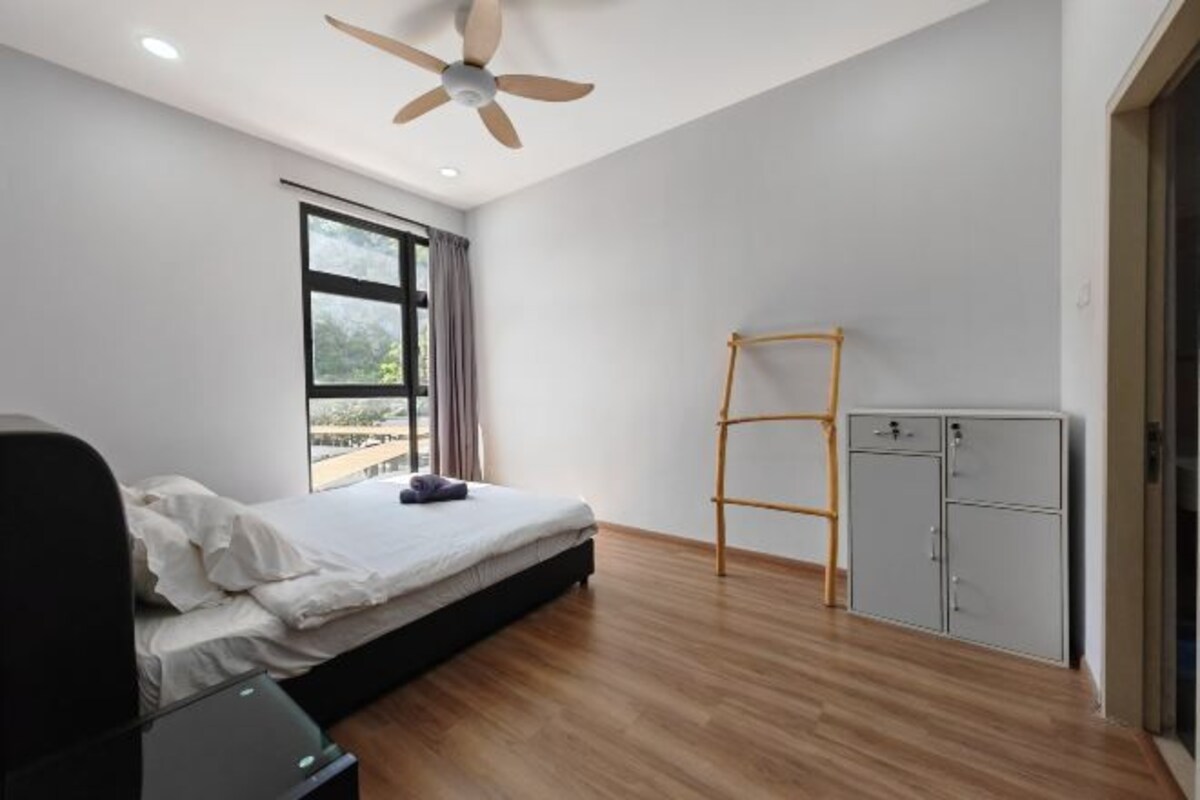 Un dormitorio con cama, ventilador de techo, ventana, armario y escalera.