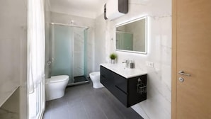 A modern bathroom with a shower, toilet, and vanity. - huaxia (Venice)