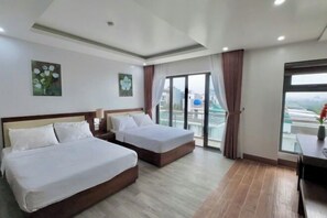 A hotel room with two beds, a desk, and a large window with a view. - SEN BIEN HOTEL - FLC SAM SON (Sam Son)