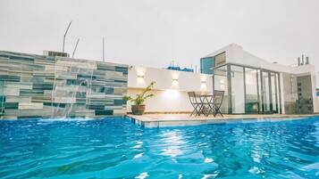 Una piscina con una casa moderna al fondo.