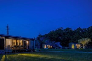 A residential property with a large house and a smaller structure, both with visible windows and a grassy yard.