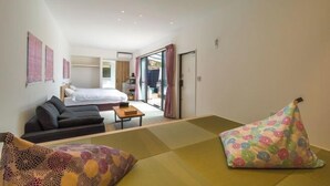 A hotel room with a bed, a sofa, a small table, and a futon. - Luxury Trailers Rikyuise (Ise)