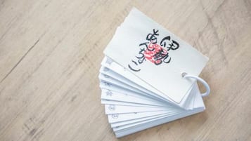 A stack of playing cards with Japanese characters on them, placed on a wooden surface.