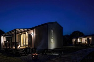 Un edificio moderno con un área de estar al aire libre techada y un hogar para fogata.