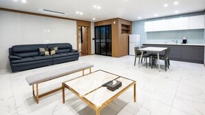 A modern living room with a sofa, a bench, and a coffee table. - Hotel signature (Yangsan-si)