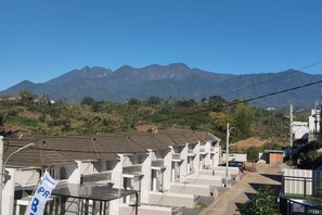 A row of white buildings with a mountain backdrop. - Villa Sunrise F1 (Dau)