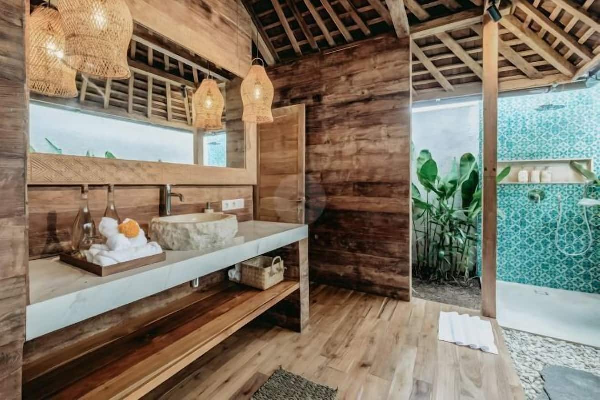 Un interior de madera con tocador de madera, luces colgantes y vistas a una zona exterior con azulejos.