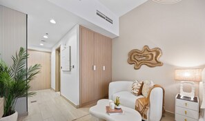 Una sala moderna con un sofá, una mesa de centro, una mesita auxiliar y una planta en maceta.