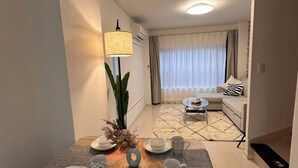 A dining area with a table set for four, a lamp, and a plant. - Relax House (Tokyo)