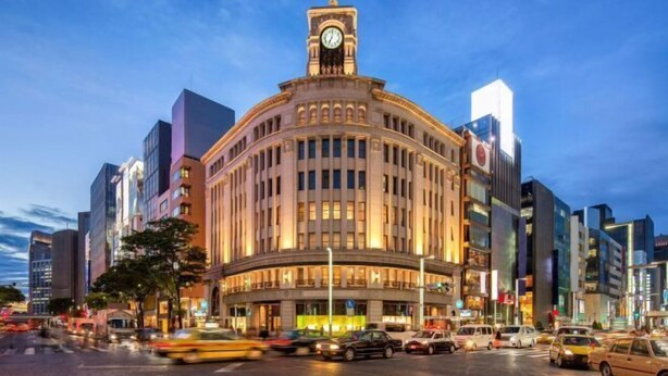 A historic building with a clock tower, surrounded by modern skyscrapers and busy streets. - Relax House (Tokyo)