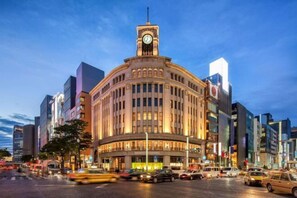 A historic building with a clock tower, surrounded by modern skyscrapers and busy streets. - Relax House (Tokyo)