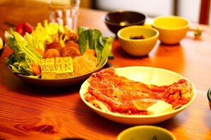 A table with various dishes, including a bowl of meat and a bowl of vegetables. - chambre d'hôte chaton (Taiki)