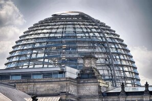 Un bâtiment moderne en verre, à plusieurs niveaux, de forme circulaire, caractérisé par une colonne centrale imposante et une structure à étages.