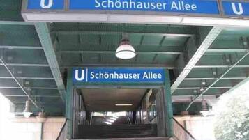 Eine unterirdische Station, mit einem Schild, das 'Schönhauser Allee' anzeigt.