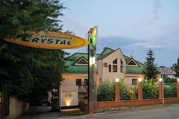 A building with a sign reading "Pension Crystal."