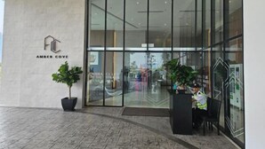 A modern hotel entrance with a reception desk, large glass doors, and potted plants. - Amber Cove Melaka Sea view town (Melaka Tengah)