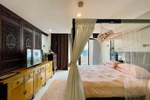 A bedroom with a bed, a television, a dresser, and a canopy bed. - 3 bedroom Penthouse at Asiana Villas in Boracay 5 minutes walk to White Beach (Boracay Island)