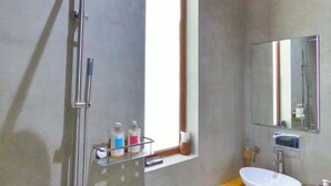 A bathroom with a shower, a sink, a mirror, and toiletries on a shelf. - Blue Coral Vashafaru Maldives (Vashafaru)