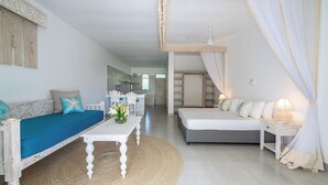 Una habitación con sofá, cama, mesa y silla.