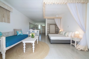 A room with a sofa, a bed, a table, and a chair. - Hibiscus (Diani Beach)