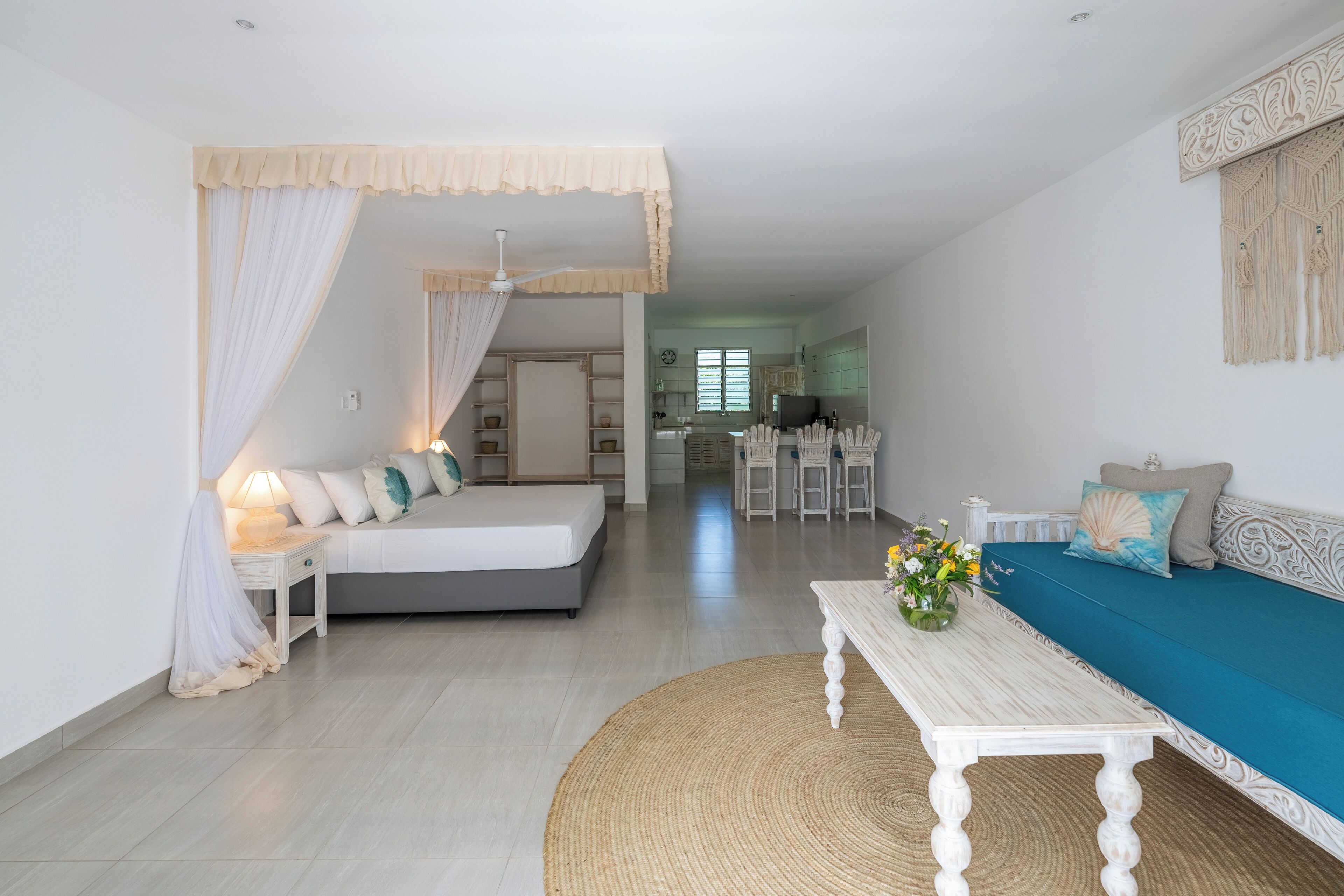 A modern living room with a bed, sofa, and dining area.