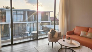 A modern living room with a large sliding glass door leading to an outdoor balcony. - Pool Access Massive Townhouse (Bophut)