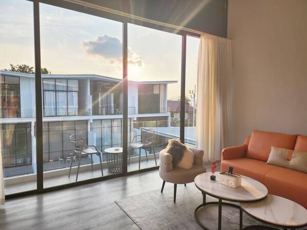 A modern living room with a large sliding glass door leading to an outdoor balcony. - Pool Access Massive Townhouse (Bophut)