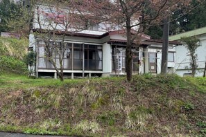 A building with a large windowed section, a sloped roof, and a visible front entrance. - Bullfighting and Nishikigoi Traditional Culture Center (Ojiya)