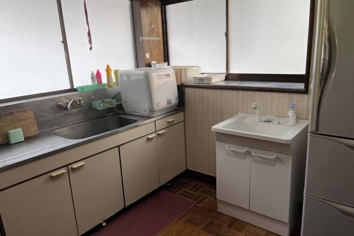 A compact kitchen with a sink, countertop, and a small refrigerator.