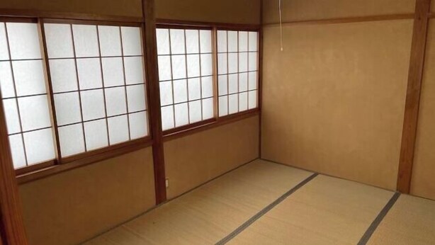 Une pièce de style japonais traditionnel, avec un sol recouvert de tatamis, des paravents shoji et des cadres en bois.