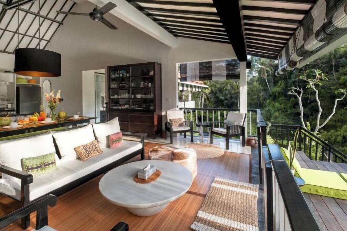 Un espacio de sala moderno con un sofá, una mesita de centro y vistas al exterior.