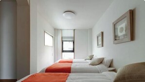 A hotel room with two beds, a window, and framed pictures on the wall. - Osaka Tamatsukuri (Osaka)