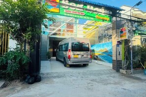 A van parked in front of a building with a colorful sign and a mural. - Sea Home Homestay (Phan Thiet)