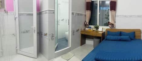 Un dormitorio con cama, escritorio, espejo y armario.