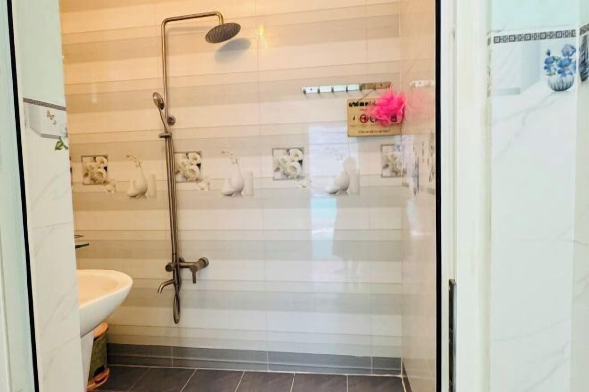 Un baño con ducha, lavamanos y azulejos decorativos.